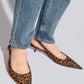 Leopard print shoes worn with blue jeans on a light gray background
