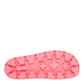 Close-up of a pink shoe sole with tread pattern on a white background
