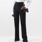 Person wearing a white shirt and black pinstripe pants on a white background