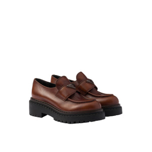 Brown platform shoes with black soles on a light gray background
