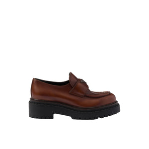 Brown leather shoe with thick black sole on a white background