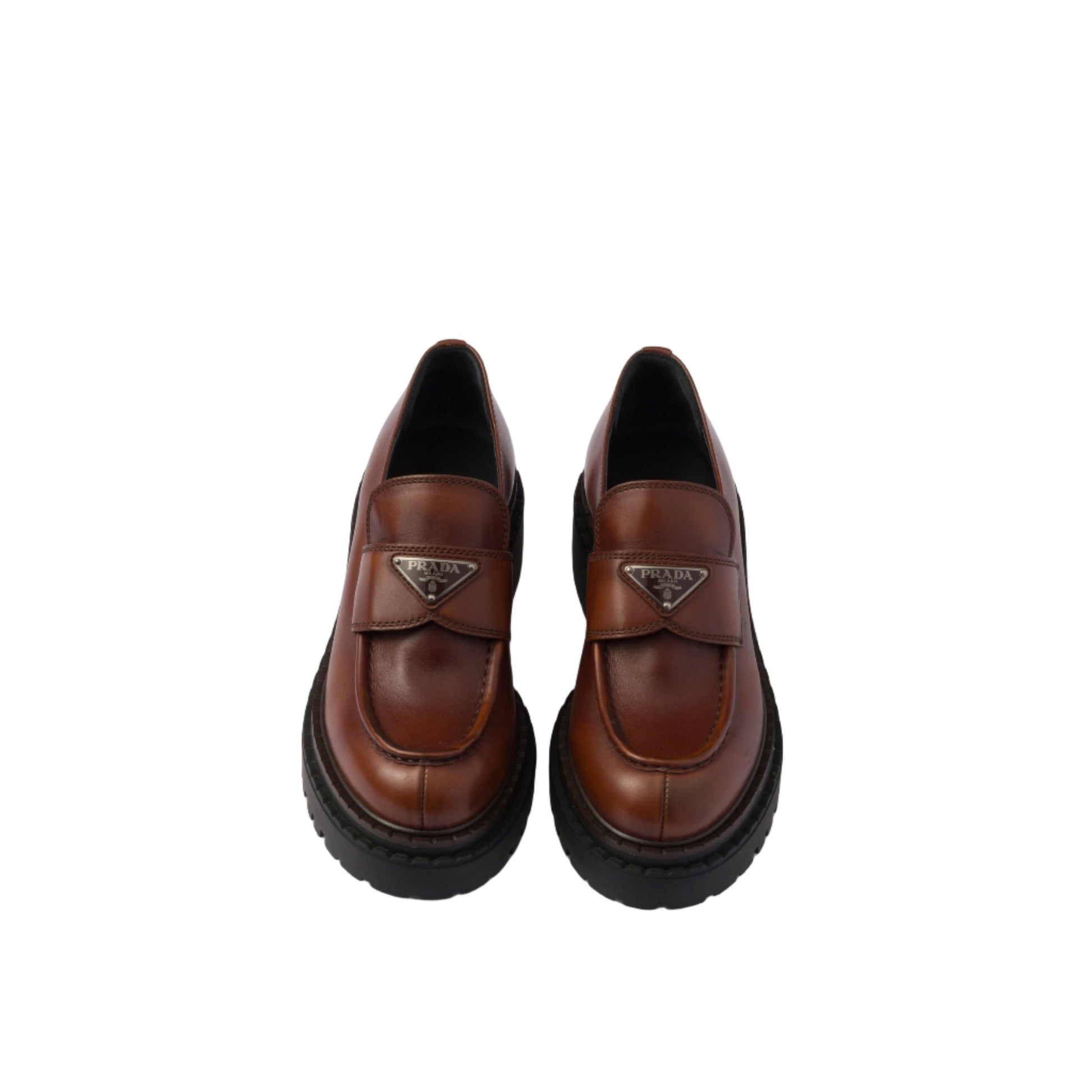 Pair of brown leather shoes with thick black soles on a white background