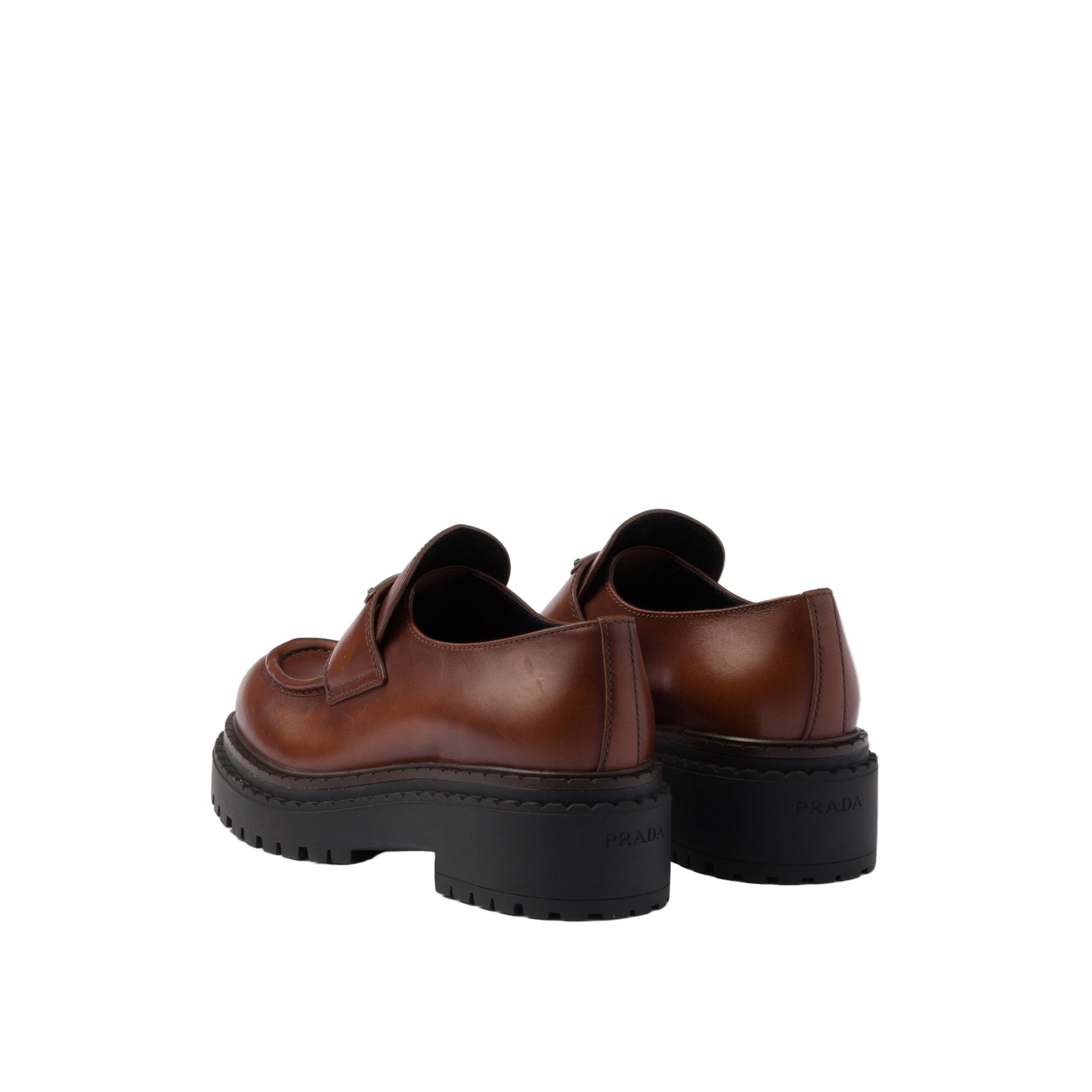 Brown leather shoes with thick black soles on a light gray background