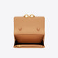 Tan handbag with gold accents on a white background