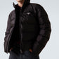 Person wearing a black puffer jacket with a brand logo on a light gray background