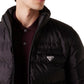 Person wearing a black puffer jacket with a brand logo on a light gray background