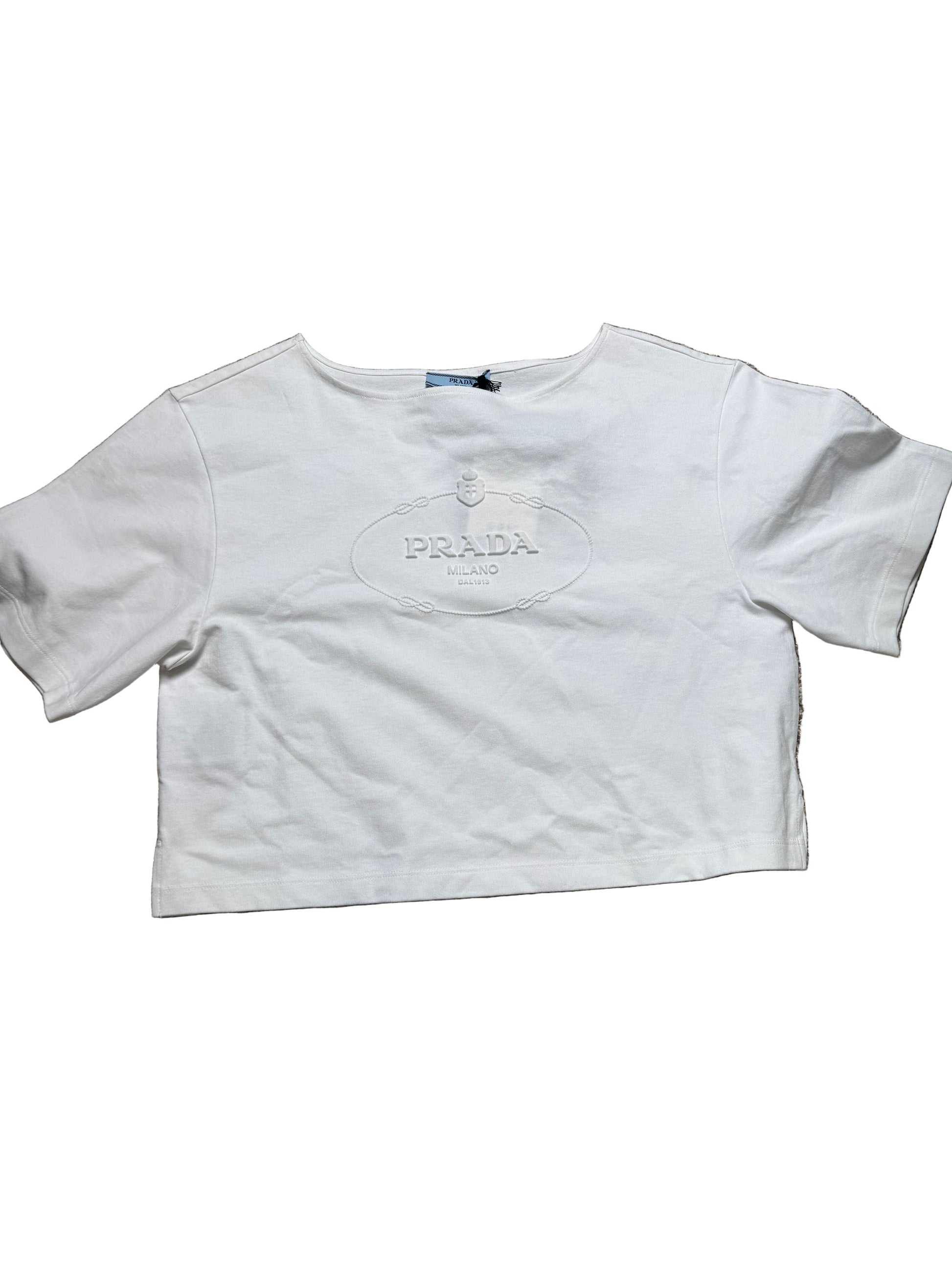 White t-shirt with a logo on a beige carpet