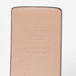 Close-up of a beige leather product with 'Valentino' branding on a light gray background