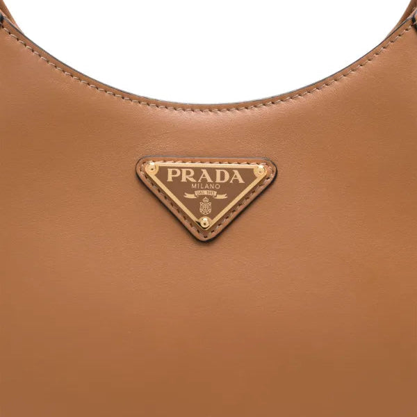 Close-up of a brown Prada handbag with the brand logo.