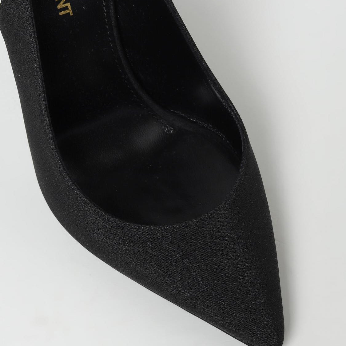 Black high-heeled shoe with 'Yves Saint Laurent' branding on a white background