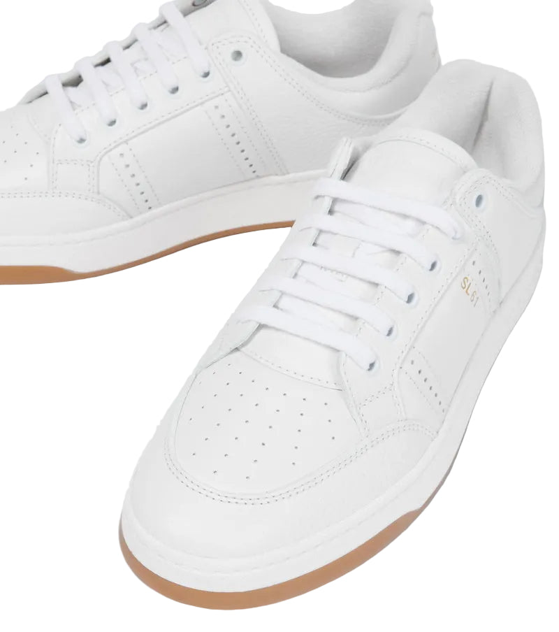 White sneakers with brown soles on a light gray background