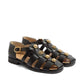 Black sandals with gold buckles on a white background