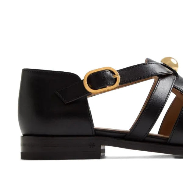Black sandal with a gold buckle on a white background