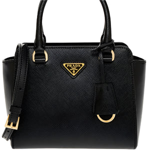 Black Prada handbag with gold accents on a white background