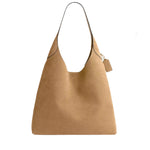 Tan handbag with a visible brand tag on a white background