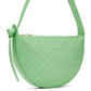 Green bottega Veneta woven handbag with a strap on a white background