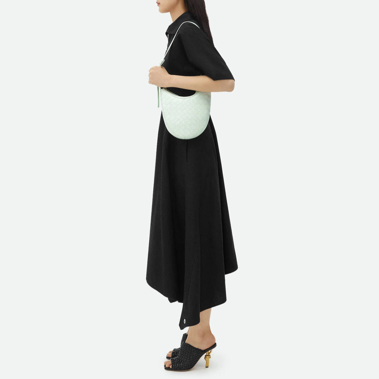 Woman holding a light green Bottega  handbag against a white background
