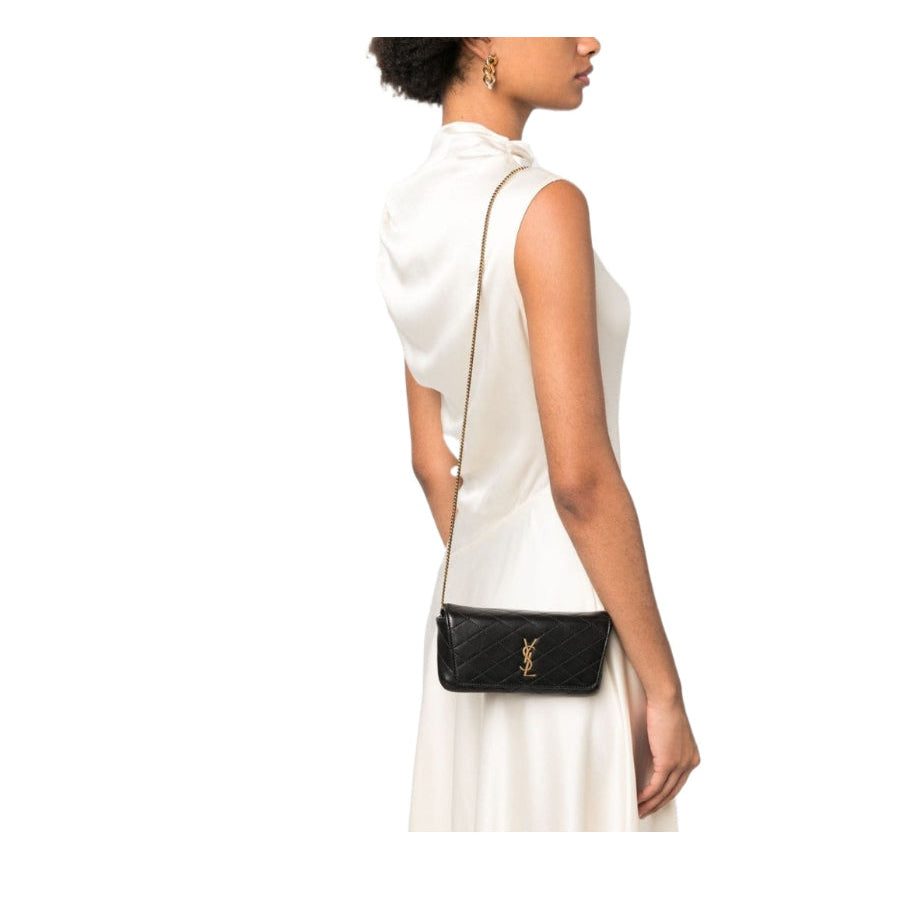 Woman wearing a white sleeveless dress with a black handbag on a white background