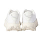 White athletic shoes with cleats on a light background