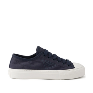Navy blue sneaker with white sole on a white background
