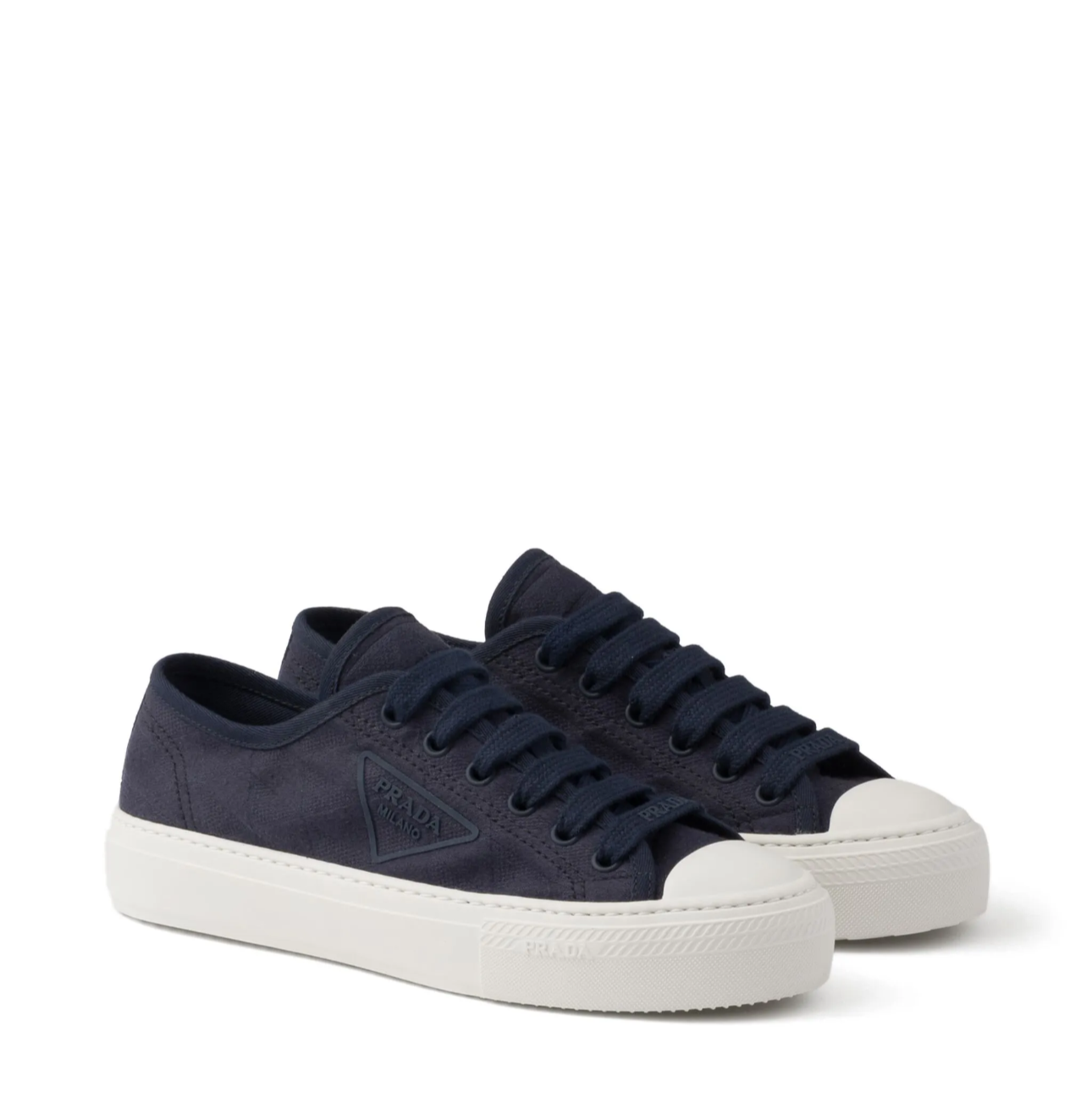 Navy blue sneakers with white soles on a white background