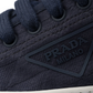 Navy blue sneaker with Prada logo on a white background