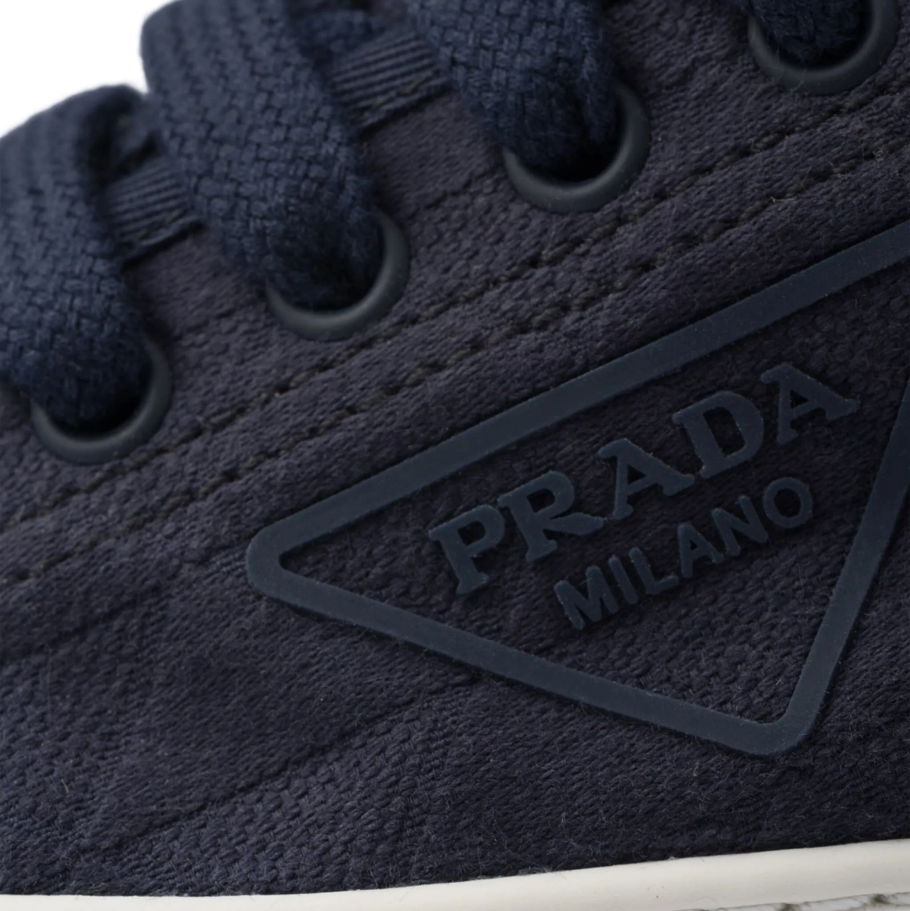 Navy blue sneaker with Prada logo on a white background