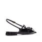 Black patent leather sandal with a strap on a white background