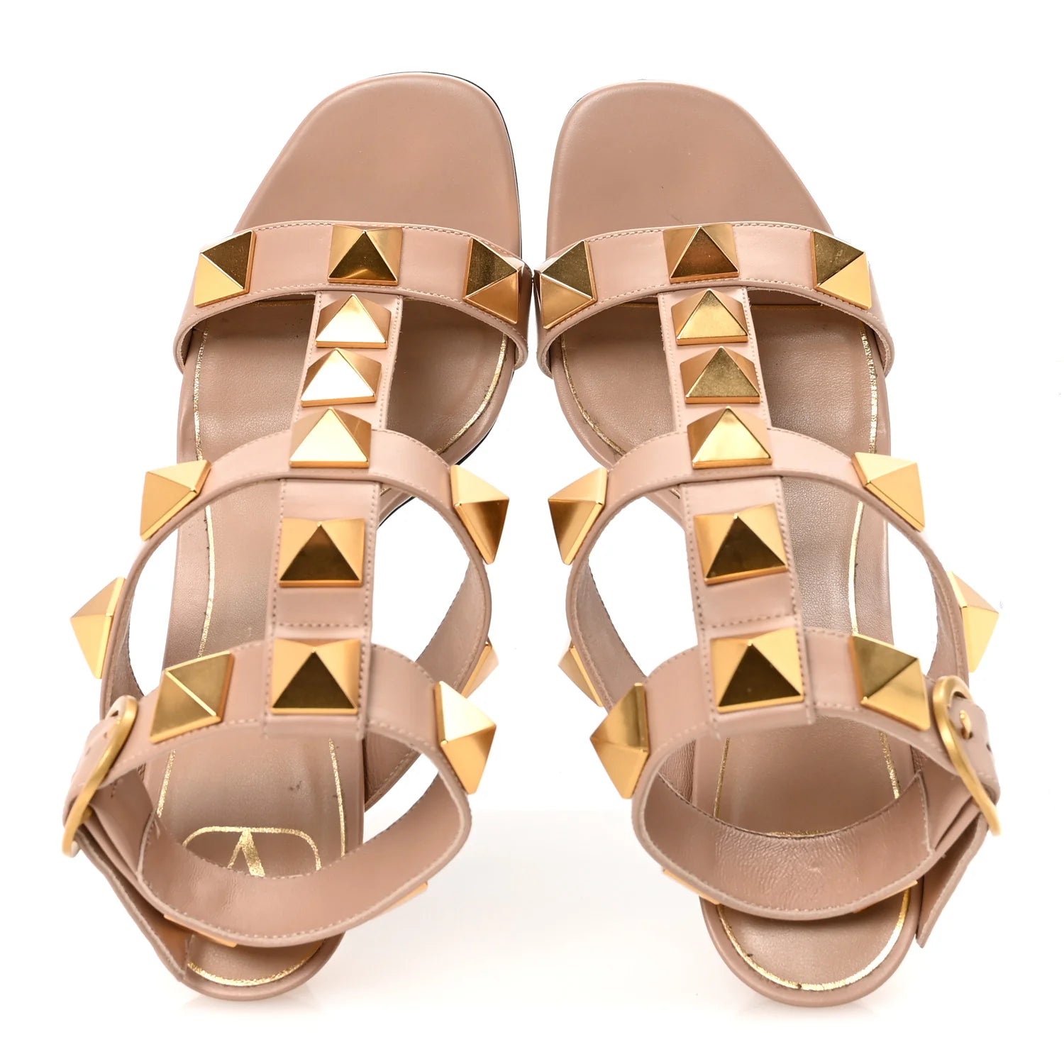 Pair of beige sandals with gold pyramid studs on a white background