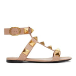 Beige sandal with gold stud details on a white background