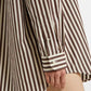Close-up of a brown and white striped shirt with a blurred background