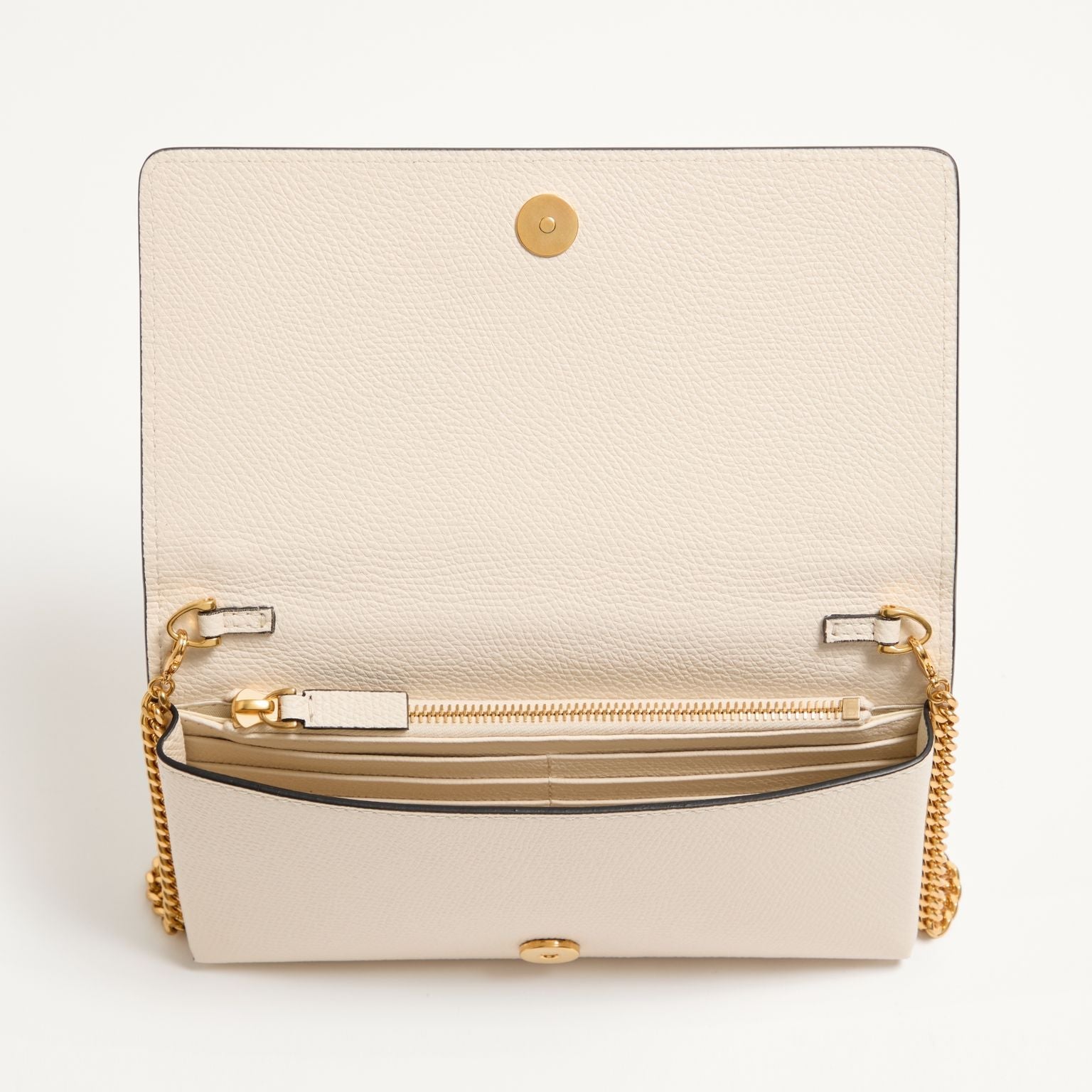 Beige handbag with gold chain strap on a white background