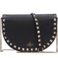Black studded handbag with gold chain strap on a white background