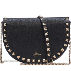 Black studded handbag with gold chain strap on a white background
