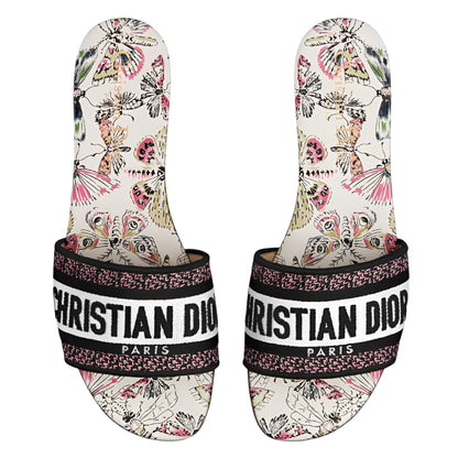 Pair of Christian Dior slides with butterfly pattern on a white background