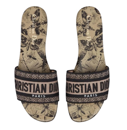 Pair of Christian Dior slides with butterfly pattern on a white background