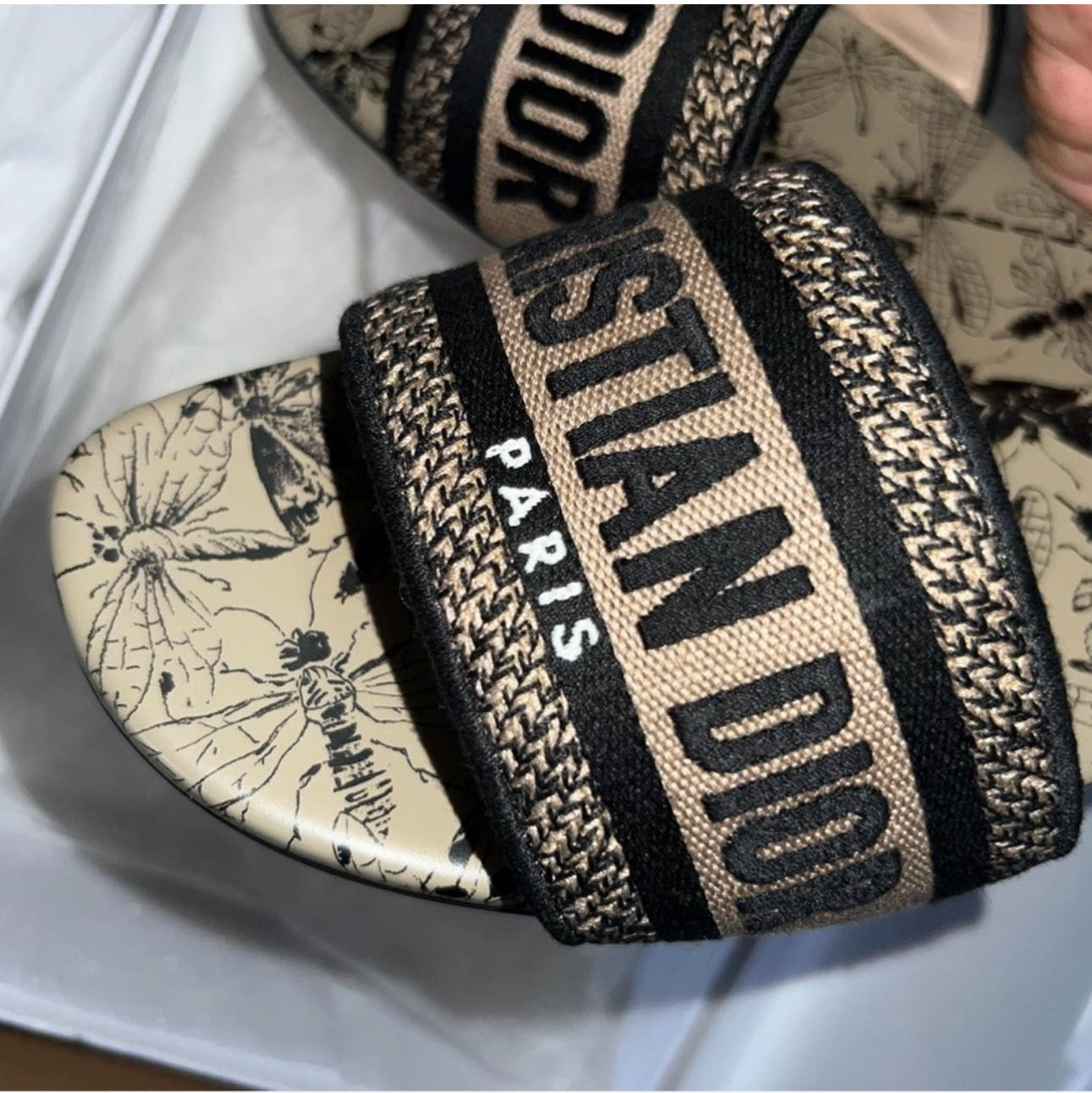 Christian Dior sandal with patterned strap and logo on a white background