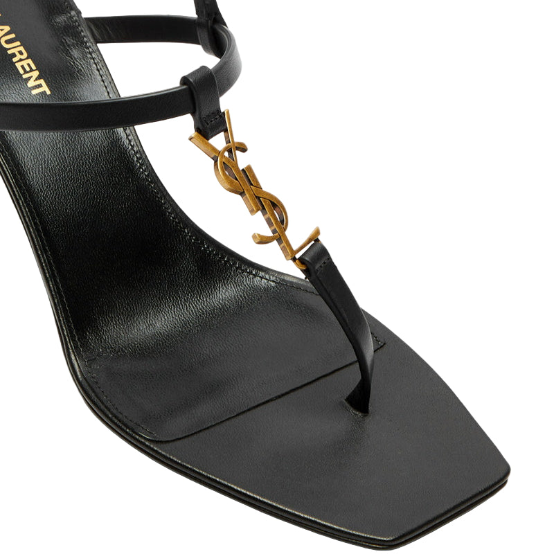 Black sandal with gold logo on a white background