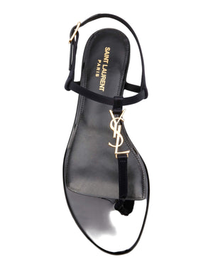 Black sandal with gold logo on a white background
