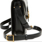 Black handbag with gold accents on a white background