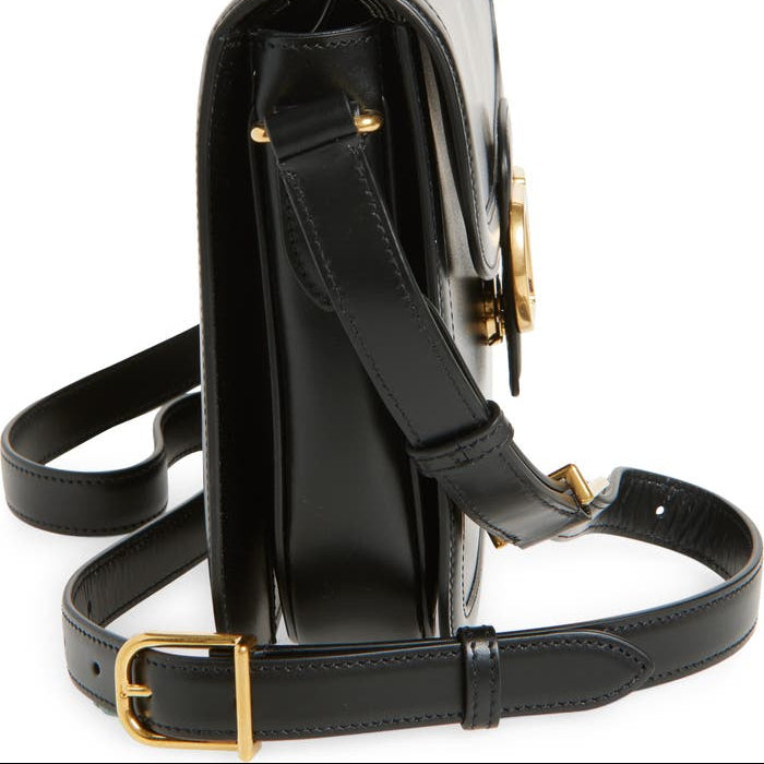 Black handbag with gold accents on a white background