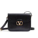 Black handbag with gold clasp on a white background