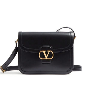 Black handbag with gold clasp on a white background
