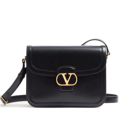 Black handbag with gold clasp on a white background