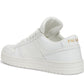 White sneaker with gold logo on a white background