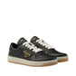 Black sneakers with white laces on a light gray background