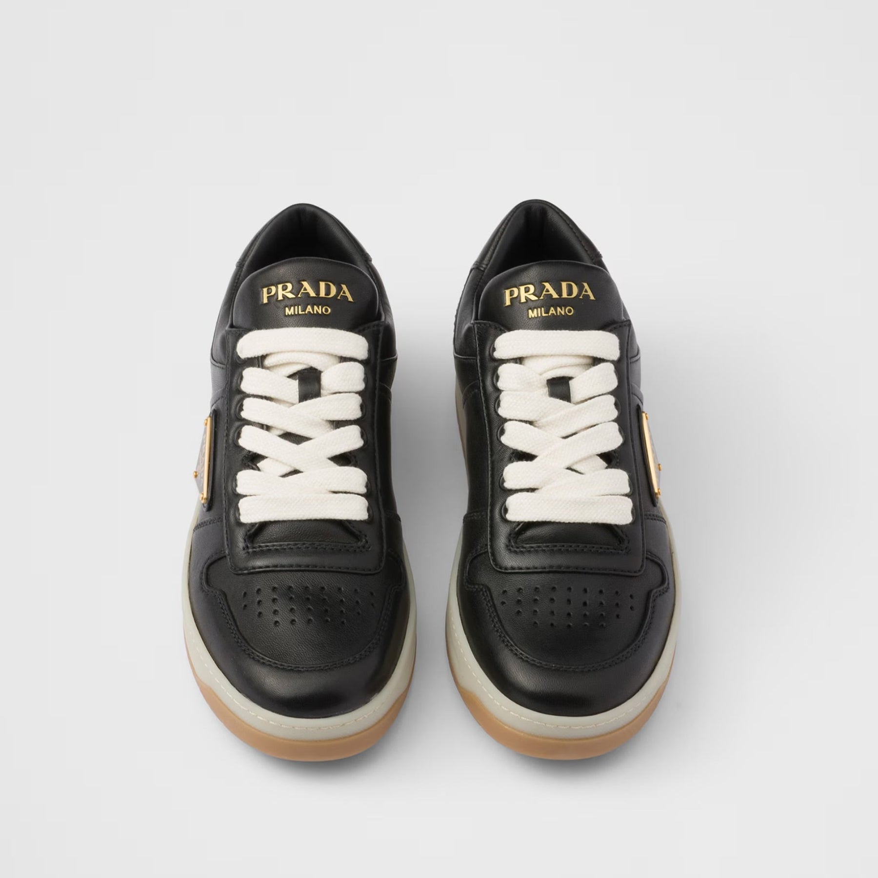 Black Prada sneakers with white laces on a light gray background