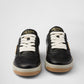 Black Prada sneakers with white laces on a light gray background