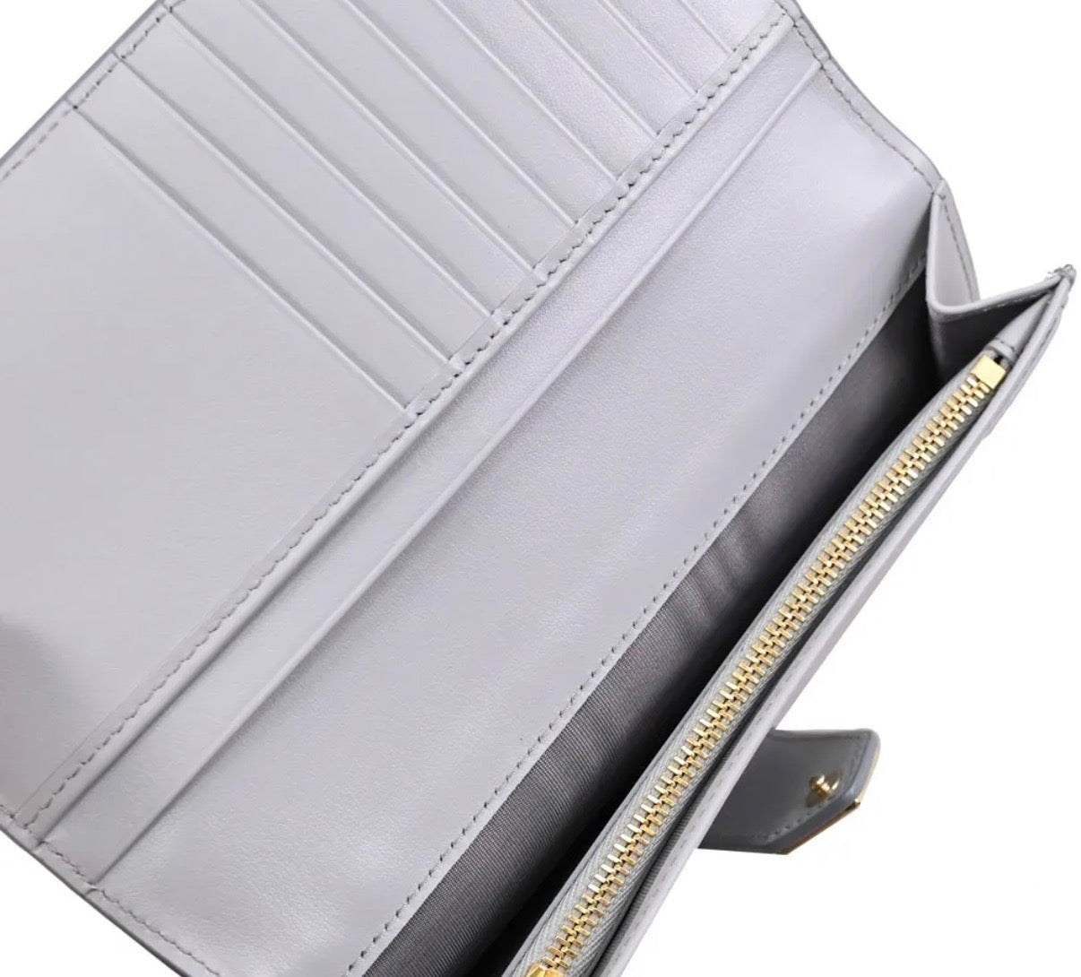 Gray wallet with gold zipper detail on a white background
