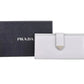 White Prada wallet with black Prada box on a white background
